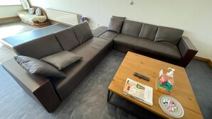 A modern living room with a sectional sofa, a wooden coffee table, and a small side table.