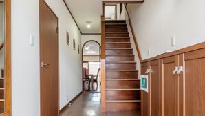 Un corridoio con pavimento in legno, una scala e armadietti in legno.