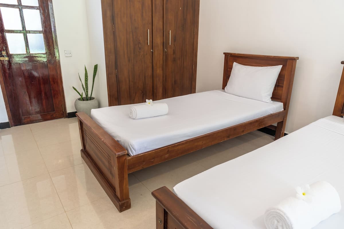 Un dormitorio con una cama de madera, un armario y una planta en maceta.