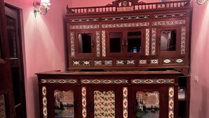 A hallway with a checkered floor, a wooden cabinet with floral patterns, and a door with a brass handle. - Vivaana  Museum Hotel (Nawalgarh)