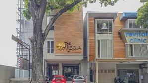 A building with a sign for 'The Regency by Ultimo' and 'Revital Clinic'. There are two cars parked in front. - Capital O 94727 Regia Cihampelas Ciwalk (Bandung)