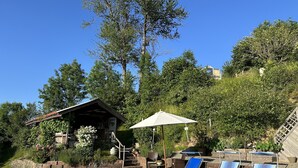 Una piscina con sillas de descanso y un área techada.
