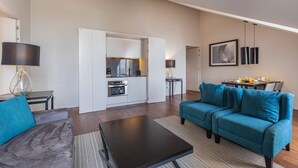 Una sala de estar moderna con un sofá, una mesa de centro y un comedor con una mesa y sillas.