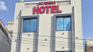 A hotel with a sign reading "AC ROOMS HOTEL" and multiple windows. - Shree Hanuman Hotel (Shri Madhopur)