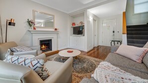 Ein Wohnzimmer mit Kamin, Fernseher und einer Treppe.