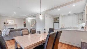 Eine moderne Küche mit weißen Schränken, einem eingebauten Backofen und einem Edelstahl-Kühlschrank.