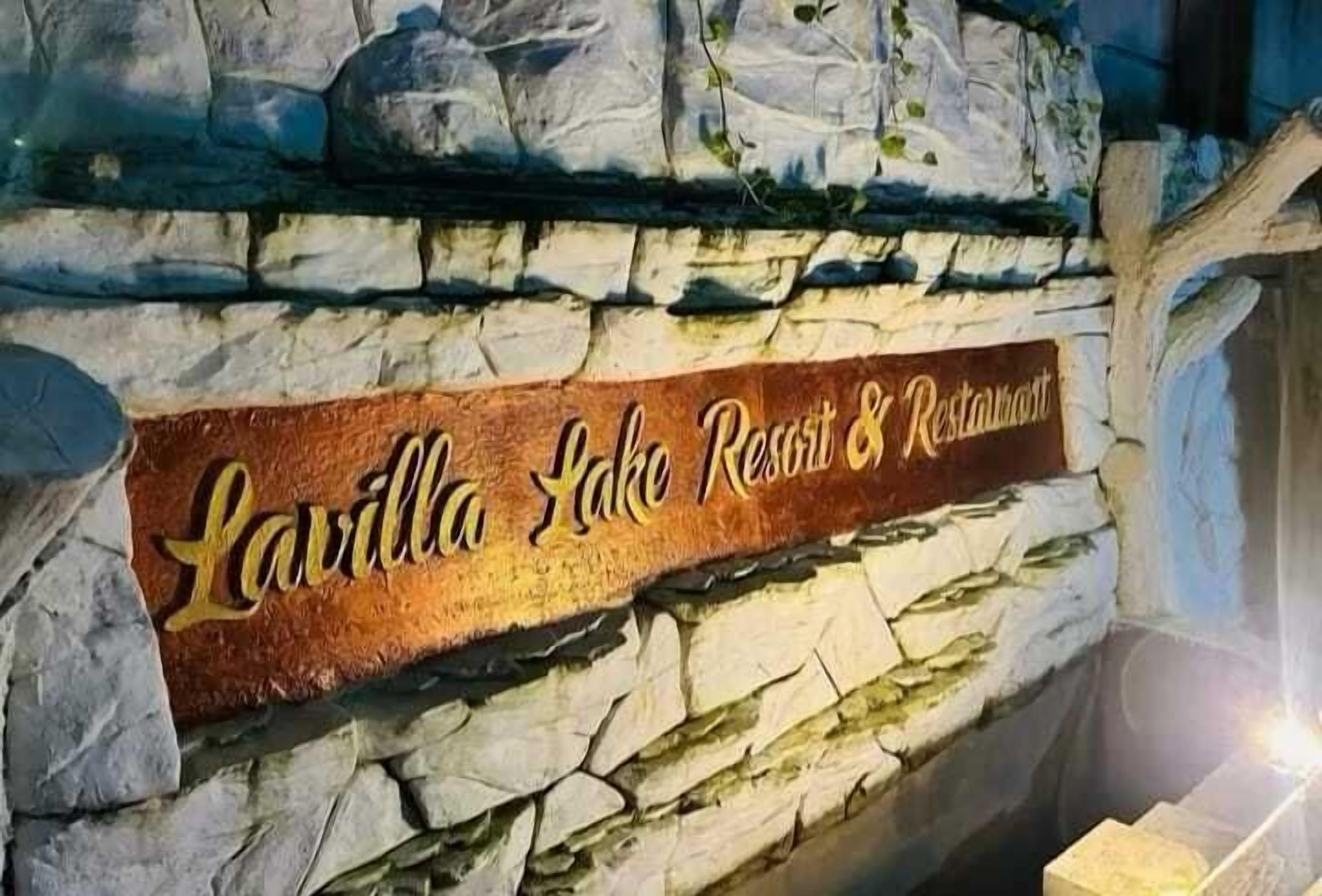 Un muro de piedra con un letrero para Lavilla Lake Resort & Restaurant.