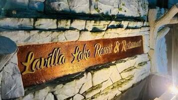 Un muro de piedra con un letrero para Lavilla Lake Resort & Restaurant.