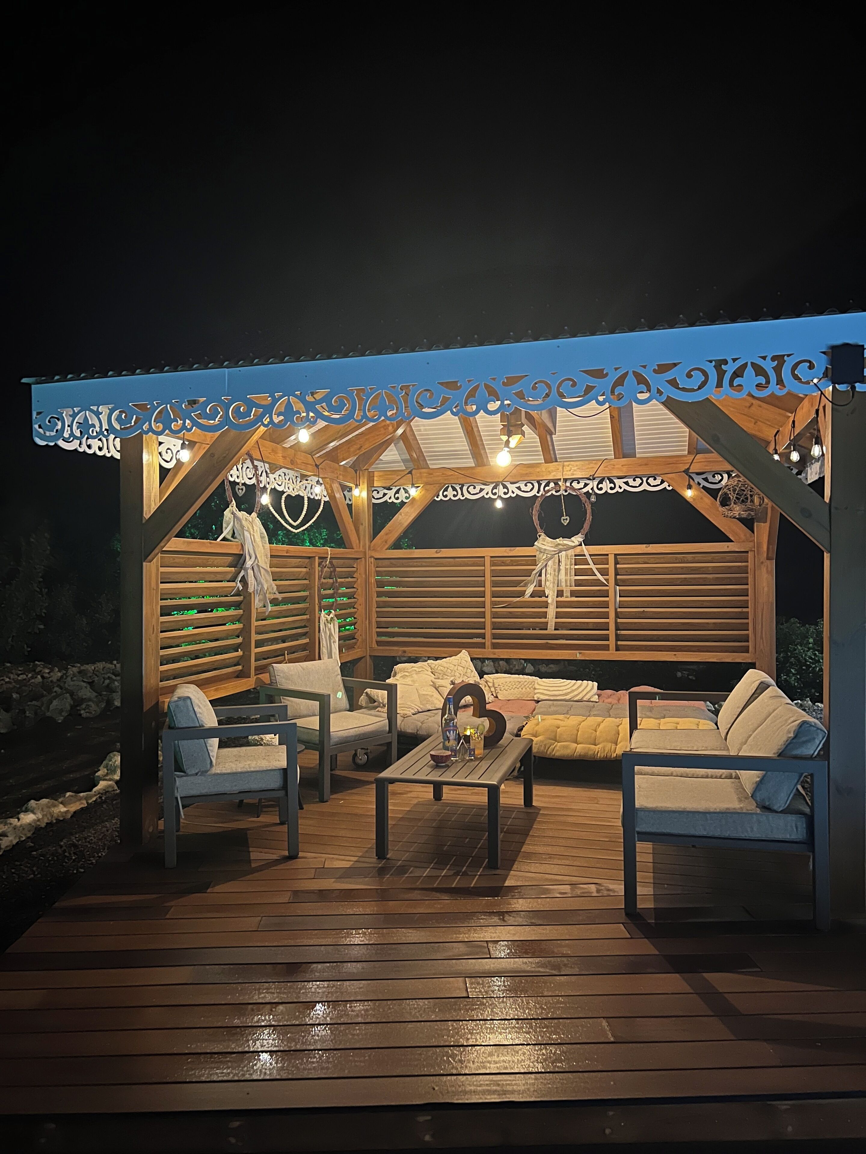 An outdoor wooden deck with seating and string lights.