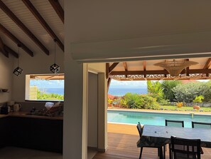 A kitchen with a view of a pool and garden.