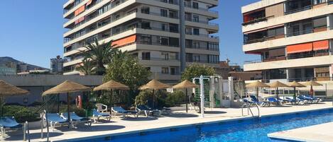 Piscine extérieure, parasols de plage, chaises longues