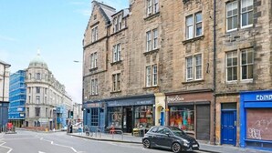 A street view with a historic building, a modern bar, and a car parked on the side. - Stunning flat near Edinburgh Castle (Edinburgh)