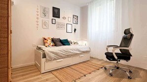 A bedroom with a bed, a desk, and a chair. - Urban Space - Affitti Brevi Italia (Lecco)
