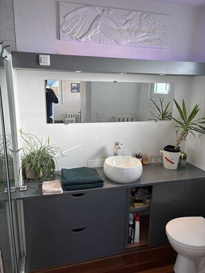 Een douche, handdoeken, zeep, toiletpapier