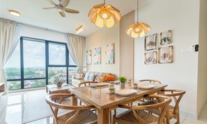 A dining area with a large window, ceiling fans, and wall-mounted artwork.