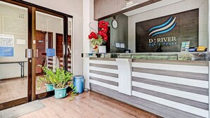 A reception desk with a clock, a digital screen, and a logo for 'D'River Guest House'. - OYO 94732 D River Cihampelas (Bandung)