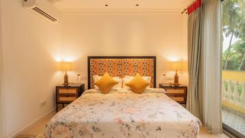 A bedroom with a bed, two bedside tables, a headboard, and a window with curtains.