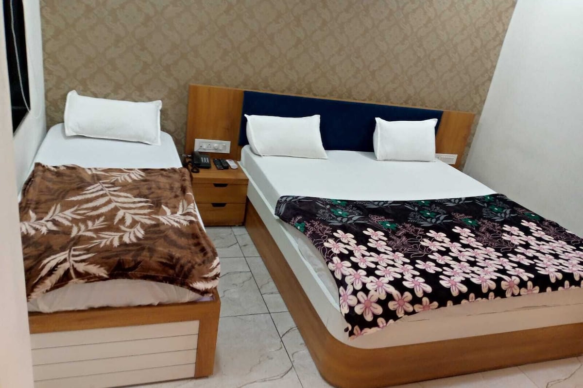 Un dormitorio con dos camas, cada una con cabecero de madera, una mesita de noche y un teléfono.