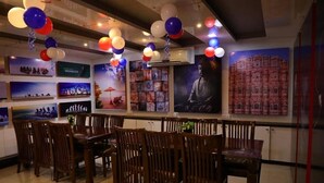 Un restaurant avec des tables et des chaises en bois, décoré de ballons.