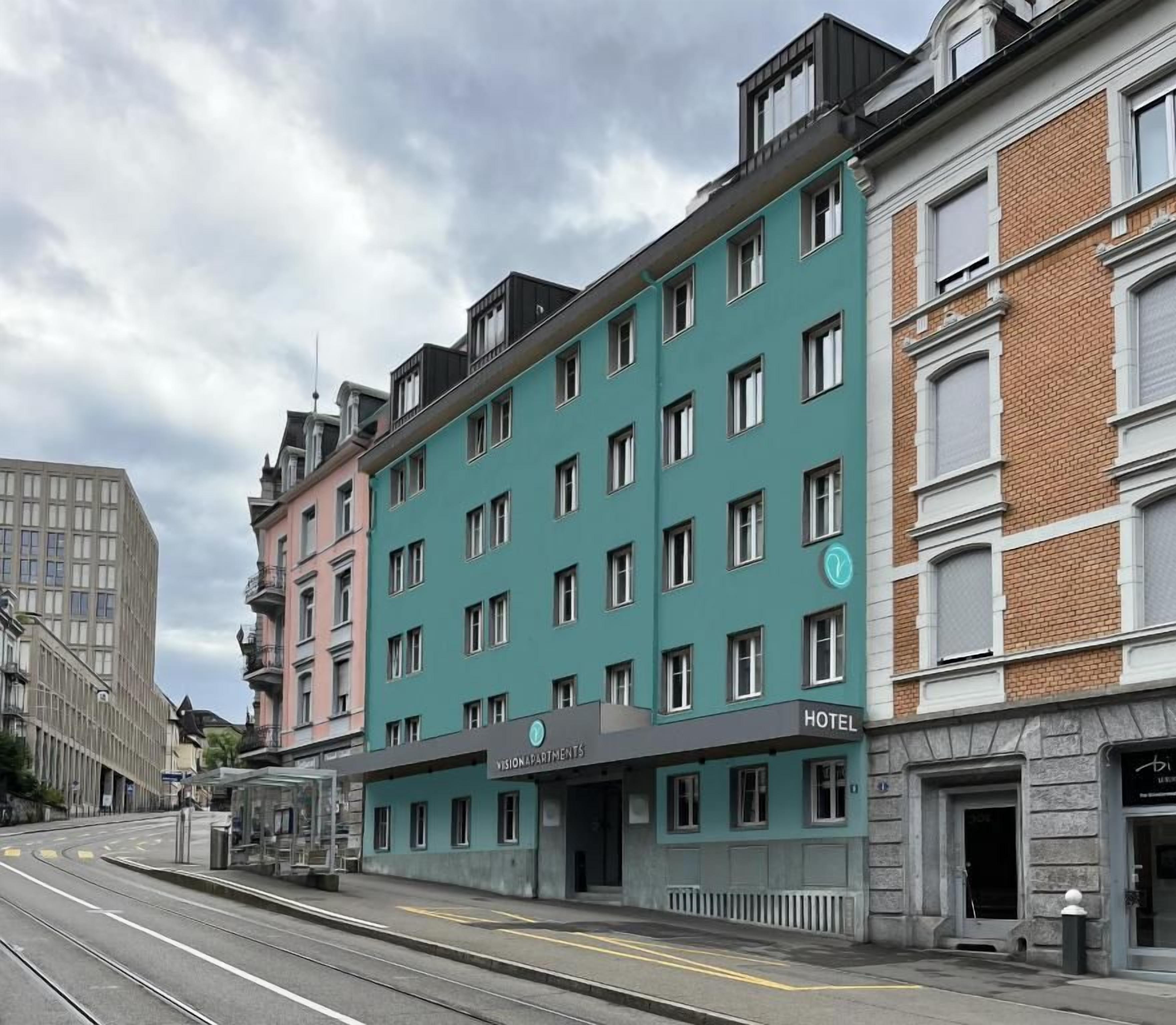 Hotel de diverses plantes amb façana moderna, situat a una cantonada amb línies de tram.