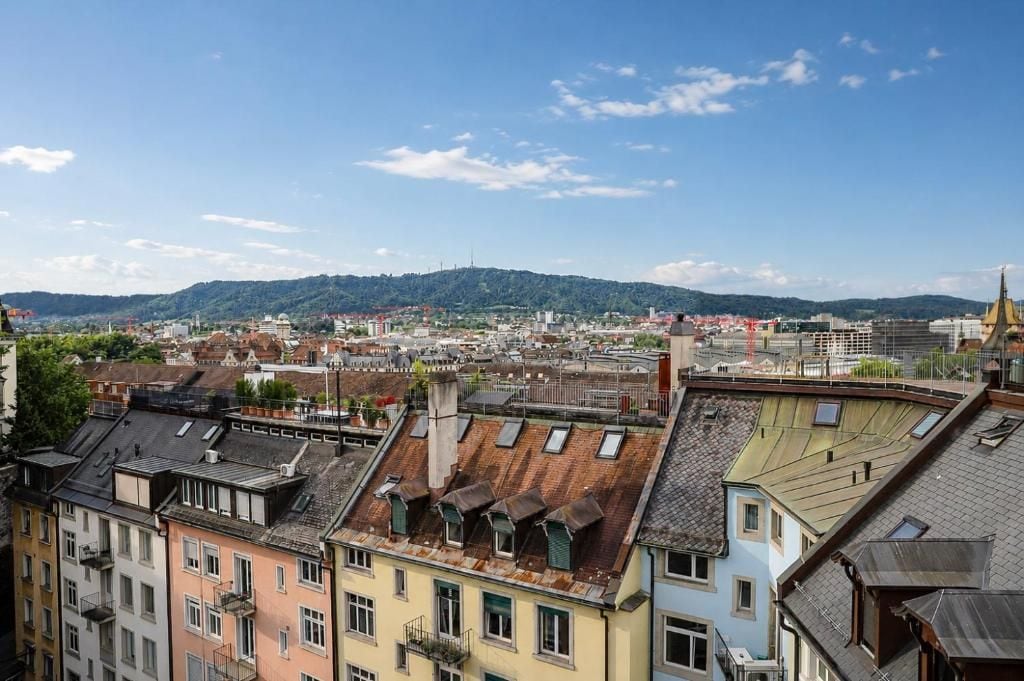 Une vue sur la ville, avec des bâtiments et une colline au loin.