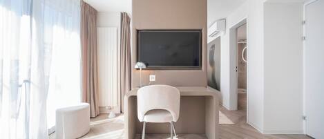 Un dormitorio moderno y minimalista con un ventanal grande, un escritorio, una silla y una cama.