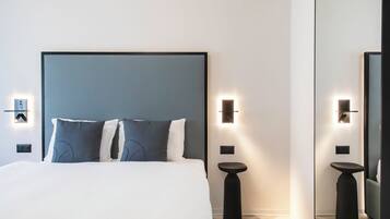 Ein modernes Hotelzimmer mit einem großen Bett, zwei Nachttischen und Wandleuchten.