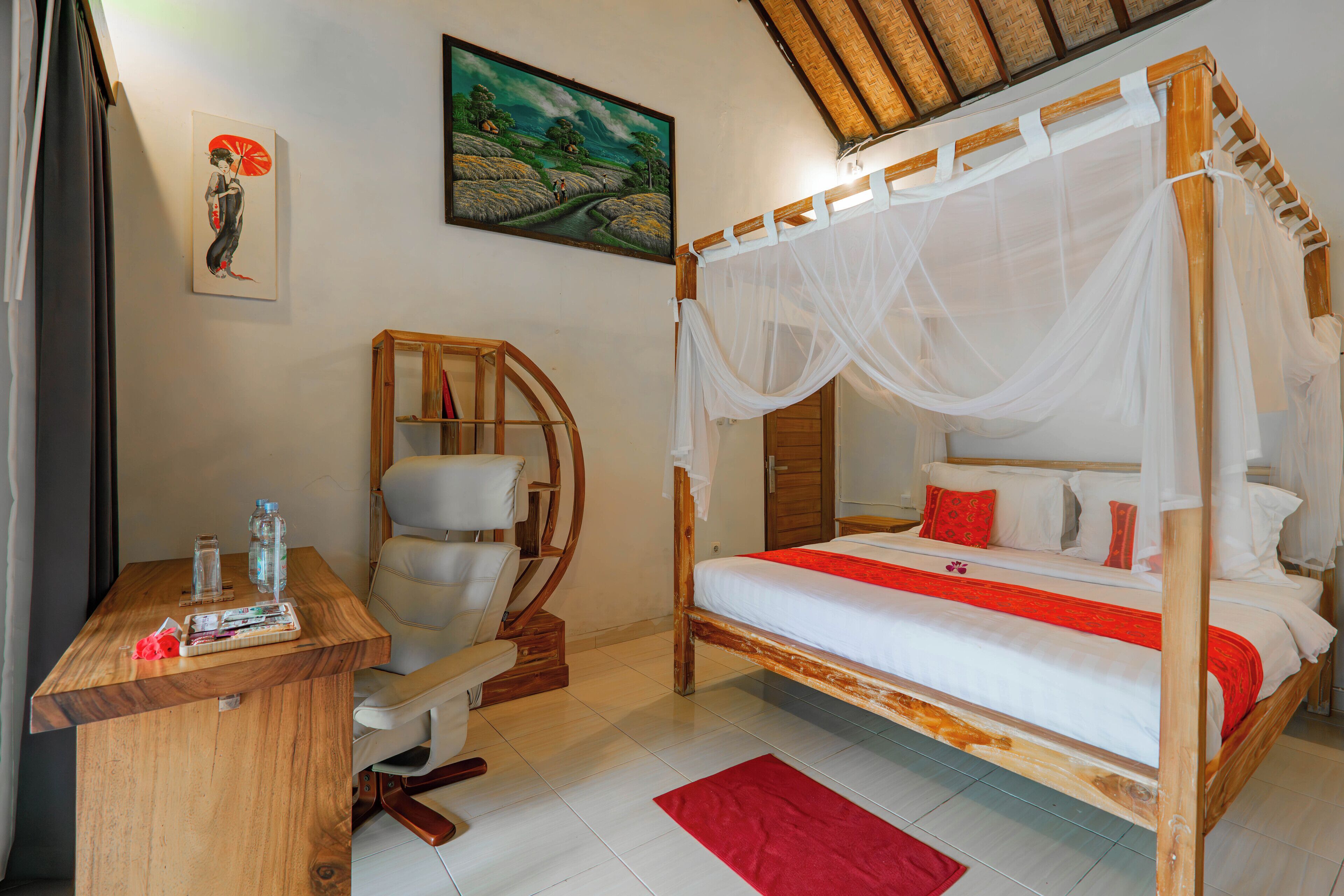 A bedroom with a four-poster bed, a wooden desk, and a chair.