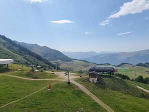 Ländliche Landschaft mit einem kleinen Gebäude, einer Überdachung und blauem Himmel.
