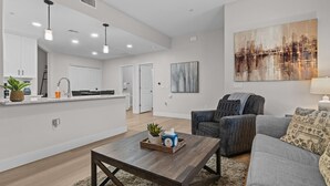 A modern living room with a sofa, a coffee table, and a painting on the wall. - Chic Uptown Condo Tucson (Tucson)