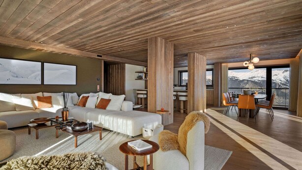 A spacious living area with a wooden ceiling, a large sofa set, a dining table, and a view of mountains through large windows. - Luxury new apartment with 4 suites, spa and services in Courchevel 1850 (Courchevel 1850)