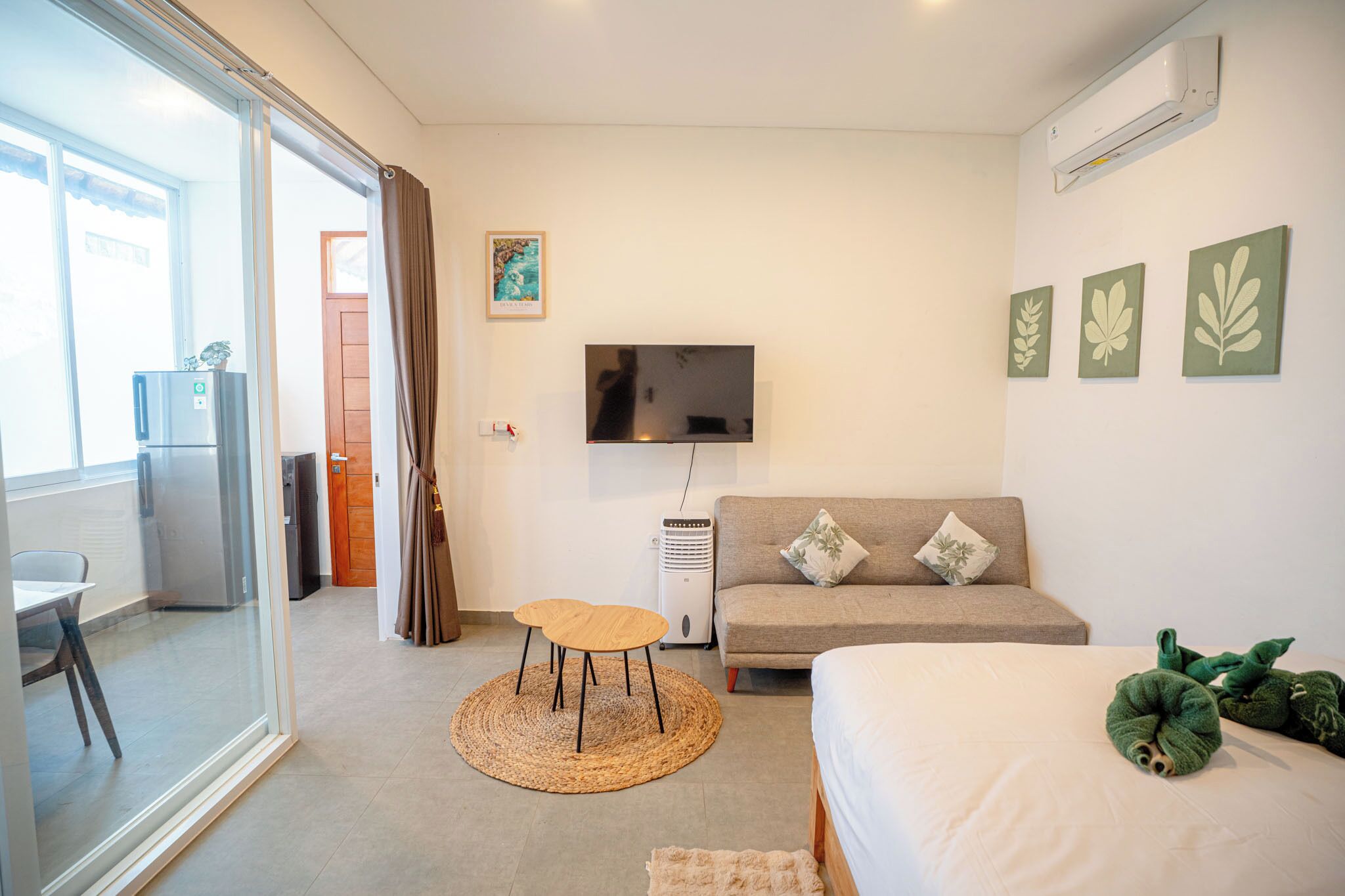 A hotel room with a bed, a sofa, a TV, and a small table.