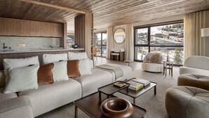 A modern living room with a wooden ceiling, a sofa set, a coffee table, and a view of a cityscape through large windows.