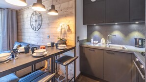 Una cocina moderna con detalles de madera, una zona de bar y un reloj en la pared.