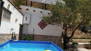 A swimming pool with a blue border, a yellow and white ball, and a solar panel on the roof. - Loma Negra Rural House, with fireplace, swimming pool and barbecue (Dúrcal)
