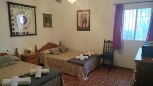 A hotel room with two beds, a desk, a chair, and a window with curtains. - Loma Negra Rural House, with fireplace, swimming pool and barbecue (Dúrcal)