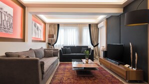 A modern living room with a sofa, a coffee table, a TV, and a decorative vase.