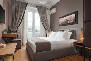 A modern bedroom with a large bed, a desk, and a window with curtains. - Acropolis Elegant Residence | Syggroy Av.12. Athens 11742, Bill & John Apartments & Villas (Athens)