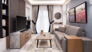 Un salon moderne avec un téléviseur à écran plat, un canapé, une table basse et une bibliothèque.