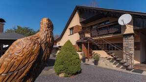 A building with a stone facade, a balcony, and a satellite dish. - Privát Prima (Podturen)