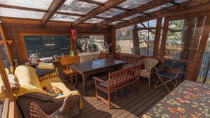 A wooden deck with a dining table, chairs, a sofa, and a cushioned bench. - Privát Prima (Podturen)