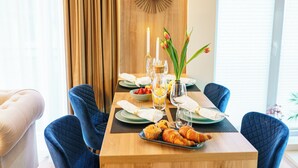 Uma mesa de jantar posta com pratos, copos, uma vela e um vaso com flores.