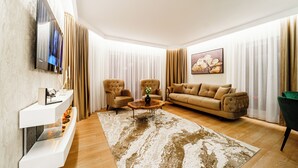 Uma sala de estar moderna com um sofá, poltronas, uma mesa de centro e uma lareira.