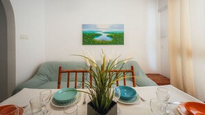Uma mesa de jantar posta com pratos, copos e um arranjo central.