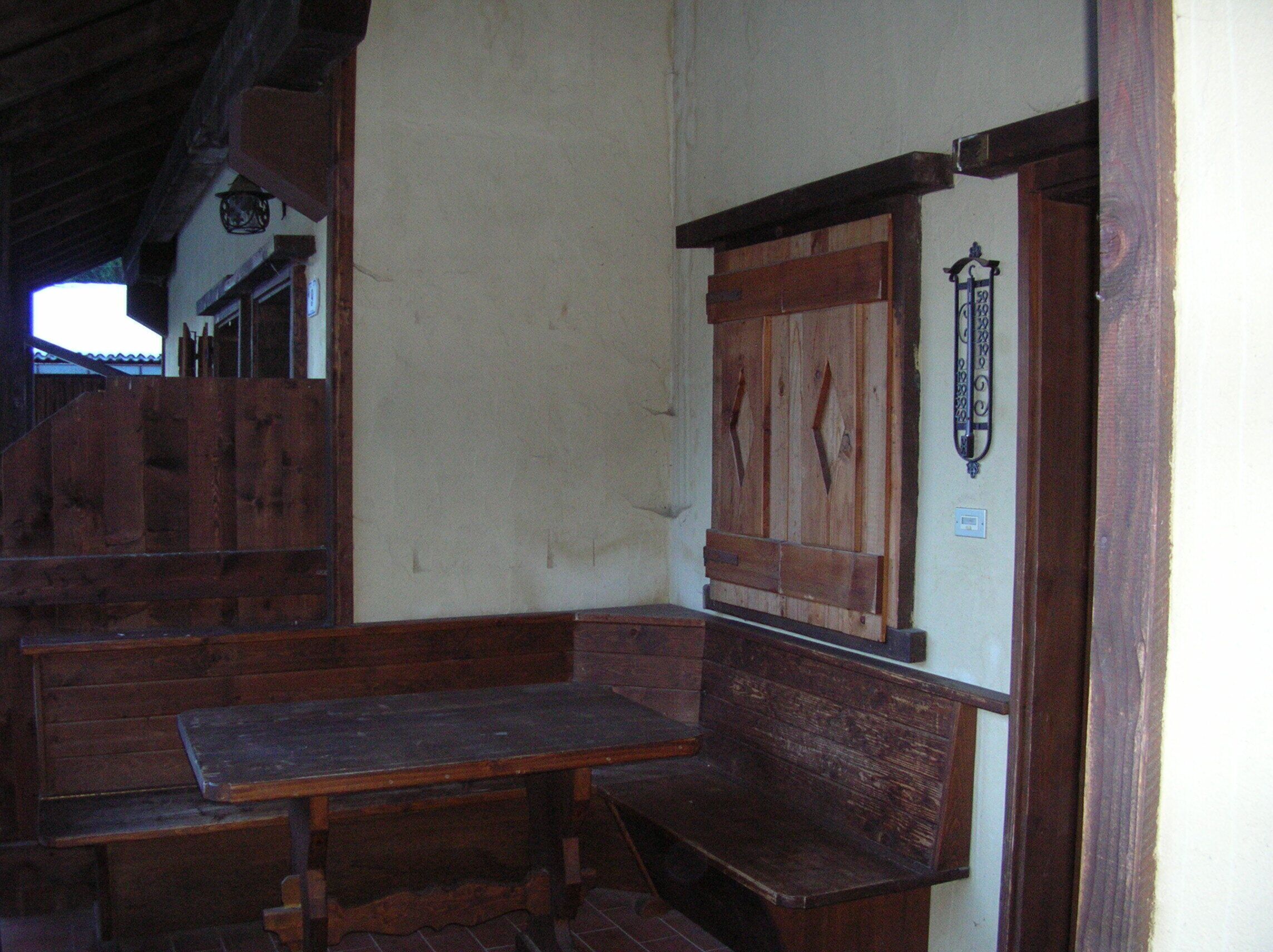 Een rustiek interieur met houten banken en een houten kast.