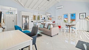 A spacious living area with a sofa, dining table, and chairs, a kitchen with modern appliances, and a ceiling fan. - Mesa Vista 36 Tierra del Sol (Noord)
