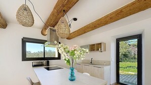 Una cocina moderna con una isla grande, un comedor y vistas a zonas verdes.