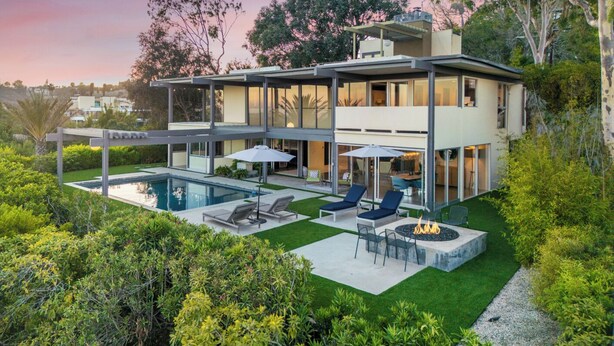 Uma casa moderna com dois andares, piscina, área de estar externa e lareira.