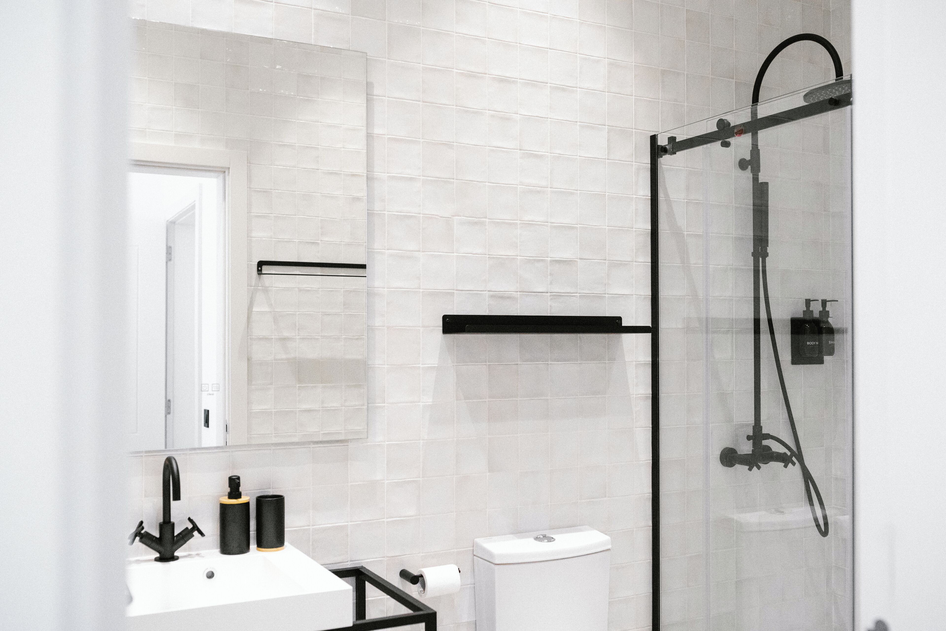 Une salle de bain moderne avec une douche à parois de verre, un lavabo blanc et des toilettes.
