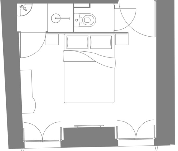 A bedroom with a bed, bedside tables, and a window.